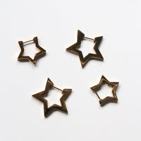 Four open star-shaped hoop earrings in a dark bronze metal finish, arranged on a plain white background.