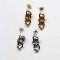 Two pairs of dangling chain-link earrings on a plain white background, one in polished gold and one in polished silver.