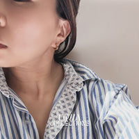 a pair of one touch hoop earrings 24k gold plated. showcasing their minimalist elegant design 