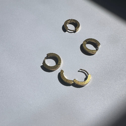 a pair of one touch hoop earrings 24k gold plated. showcasing their minimalist elegant design 
