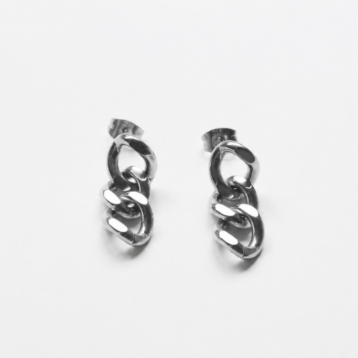 A pair of silver-toned huggie hoop earrings with a twisted chain link design, displayed on a clean white background.