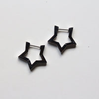 A pair of silver star-shaped hoop earrings on a plain white background.