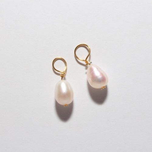 A pair of gold hoop earrings with teardrop-shaped white freshwater pearls, displayed on a clean white background.