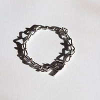 Silver handmade chain bracelet on a light gray background 