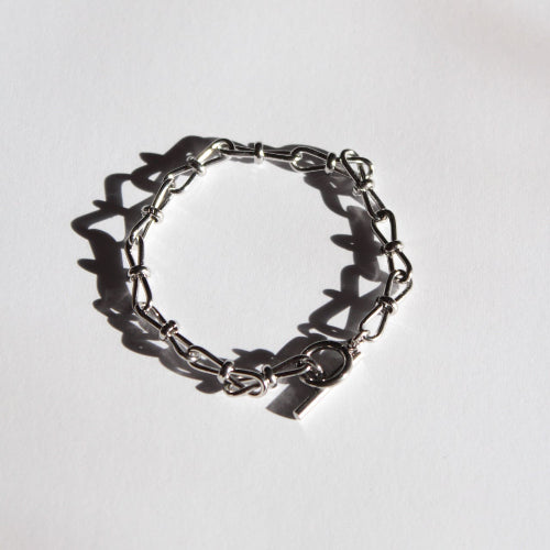Silver handmade chain bracelet on a light gray background 
