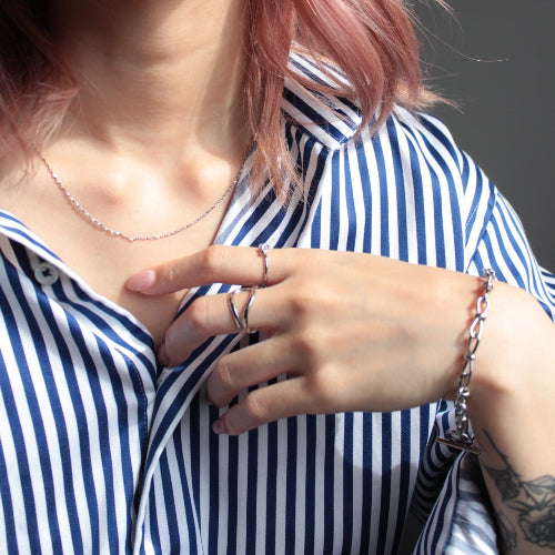Close-up of a person wearing a blue and white striped shirt with a focus on their hand and face.
