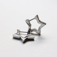 A pair of silver-toned geometric star-shaped earrings on a clean white background.